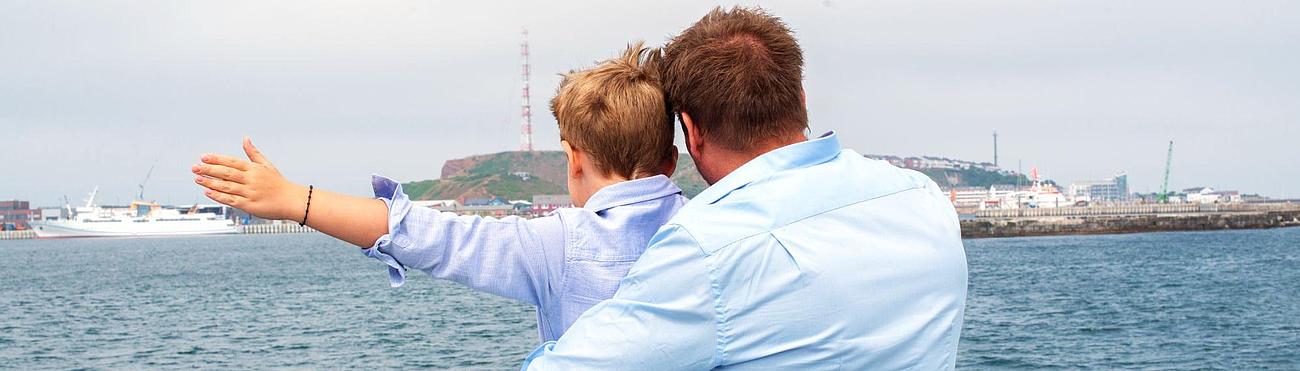 Father and son on the "Halunder Jet"'s deck, with Heligoland in the background 