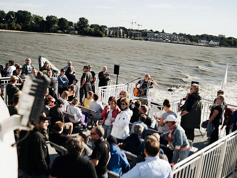 Guests on deck listening the music and enjoying the good weather 