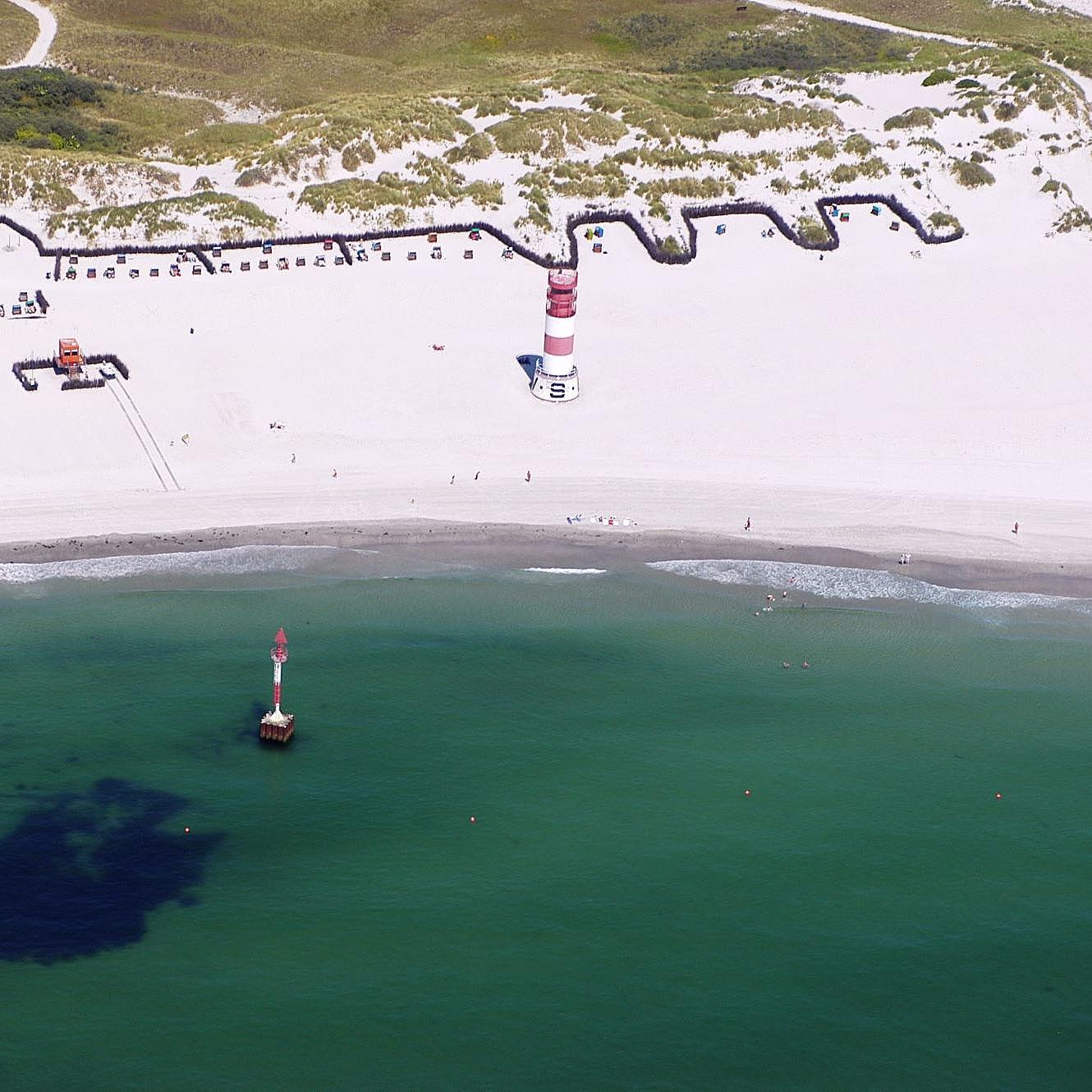 Badestrand mit Leuchtturm.