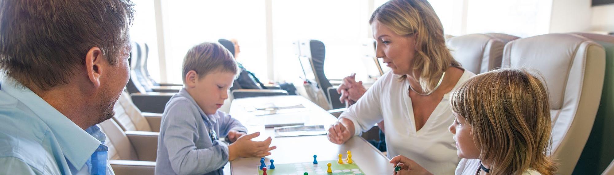 Parents playing a game with their children while being on the Halunder Jet