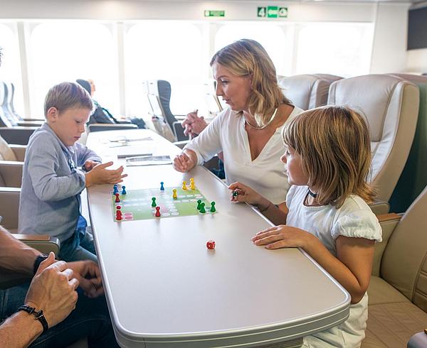 Parents playing a game with their children while being on the Halunder Jet