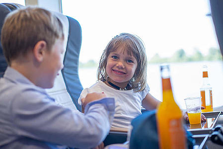 Two children on board having a soft drink