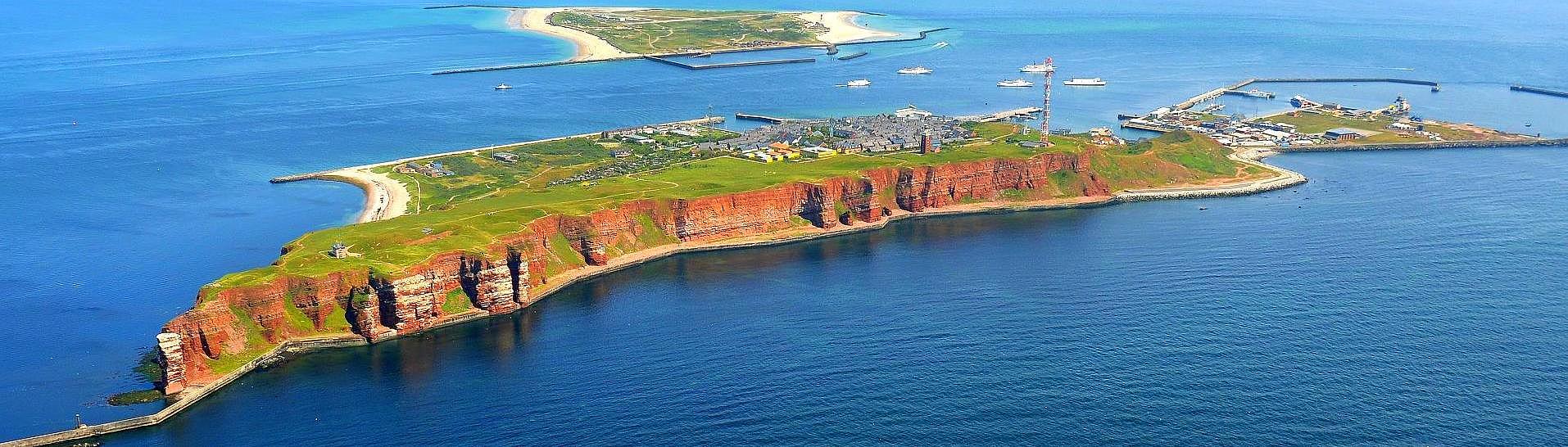 Luftaufnahme von Helgoland, mit Schiffen im Hintergrund.