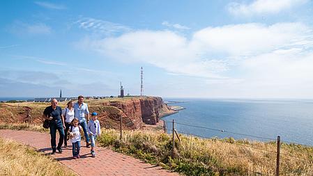 Family walking, houses and the landmark "Lange Anna" in the background