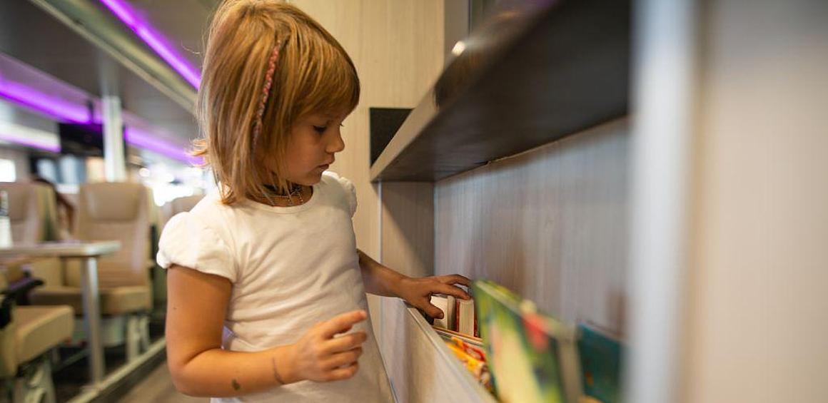 Mädchen vor der Bücherwand auf dem Halunder Jet
