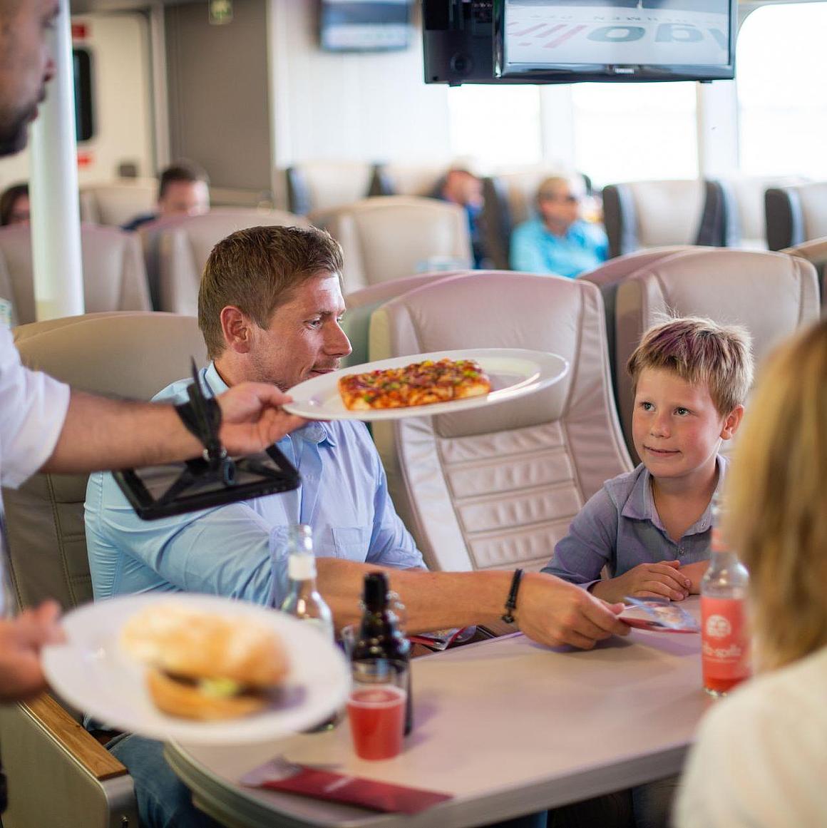 A steward serves food to a family